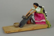 WOMAN GRINDING CORN