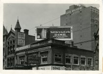 Black and white glossy photo showing buildings along the east side of Woodward Avenue just north of the Central United Methodist Church