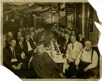 Sepia-toned photo showing a large group of men who are seated at a Detroit Fire Department dinner