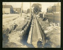 Sepia-toned photo showing underground electrical duct banks being constructed along the south side of River Street