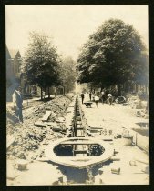 Sepia-toned photo showing underground electrical conduits being constructed beneath a residential street