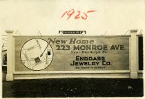 Black and white photographic print depicting a Walker & Co. billboard displaying an advertisement for the Enggass Jewelry Co.