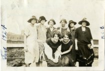 Sepia-toned photo of eight employees of the Merchants Credit Bureau posing on the roof of the Merchants Building, on the east corner of Grand River Avenue and Broadway Avenue