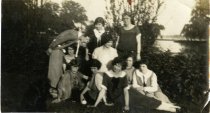Sepia-toned photo of ten employees of the Merchants Credit Bureau posing in front of one of the lakes on Belle Isle