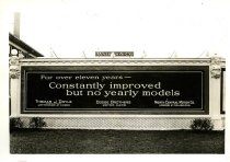 Black and white photographic print depicting a Walker & Co. billboard displaying an advertisement for Dodge