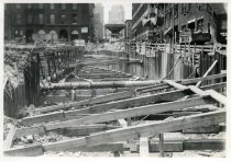 Digital scan of a sepia-toned photo of the bracing above the excavation for the Detroit-Windsor Tunnel through Randolph Street, as taken facing north near Franklin Street