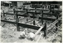 Digital scan of a sepia-toned photo of the foundation for the ventilation building at the construction site for the Detroit Terminal of the Detroit-Windsor Tunnel