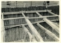 Digital scan of a sepia-toned photo of bracing along the sides of an excavation at the construction side of the Detroit terminal of the Detroit-Windsor Tunnel