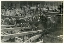 Digital scan of a sepia-toned photo of the southeast corner of the construction site for the Detroit terminal of the Detroit-Windsor Tunnel, as taken facing the southwest