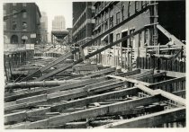 Digital scan of a sepia-toned photo of the bracing above the excavation for the Detroit-Windsor Tunnel through Randolph Street, as taken facing north near Franklin Street