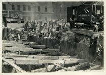 Digital scan of a sepia-toned photo of the southeast corner of the construction site for the Detroit terminal of the Detroit-Windsor Tunnel, as taken from the intersection of Franklin Street and Randolph Street, facing southwest