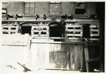 Digital scan of a sepia-toned photo of the underpinning on the eastern face of the brick building at 202 Randolph Street, put in place during the construction of the Detroit-Windsor Tunnel
