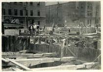 Digital scan of a sepia-toned photo of the southeast corner of the construction site for the Detroit terminal of the Detroit-Windsor Tunnel, as taken from the intersection of Franklin Street and Randolph Street, facing southwest