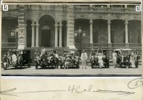 Black and white photographic print depicting circus performers posed on five Packards in front of 'Iolani Palace, Honolulu, Hawaii