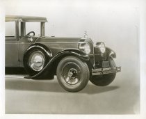 Black and white photographic print taken in a studio depicting the front, left side of a Packard automobile