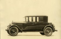 Black and white photographic print depicting a Packard automobile from the right