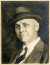 Mounted sepia-toned head-and-shoulders portrait photograph of Charles E