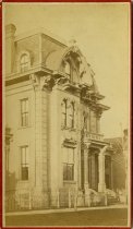 Cabinet card bearing a sepia-toned panoramic photograph of the exterior of the Holbrook House at 6 West Adams Avenue