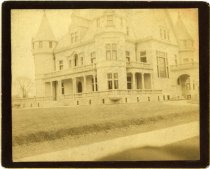 Cabinet photograph bearing a sepia-toned photo of the Colonel Frank J. Hecker Houseas taken at the corner of Woodward Avenue and East Ferry Street