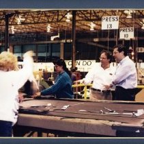 Color photo of Spencer Abraham with workers in warehouse or factory