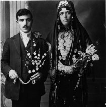 Black and white studio photo of man and woman holding flowers