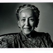 Black & white portrait of Aliya Hassen smiling to camera