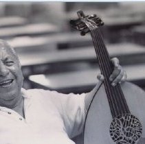 Black and white photo of laughing man with oud