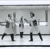 Black and white photo of people in traditional dress dancing