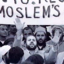Black and white photo of a group of men under a banner