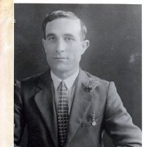 Black and white studio portrait of man in suit