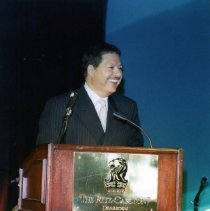 Color photo of man at podium smiling