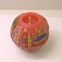 Orange wax candle with painted engraving of Jerusalem