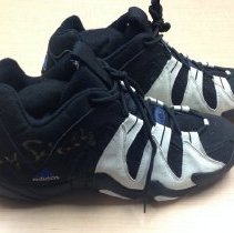 Black and white Adidas basketball shoes signed in gold on the outer heel