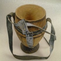 wooden milk sourer with hash markings along sides & leather straps