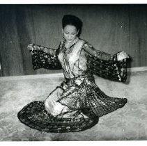 Black and white photo of Aliya dancing/kneeling in a dress