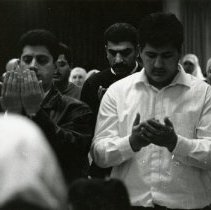 Photo of men standing in prayer at mosque