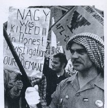 Black and white photo from interior of protestors holding signs