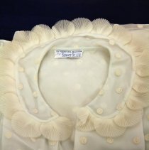 Bedjacket folded to highlight collar and maker's tag