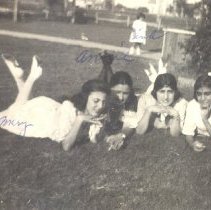 1918-01 Black & white photo of four girls laying in the grass w notes in bl