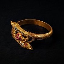 Gold bracelet w two serpent heads embellished with white and red gems