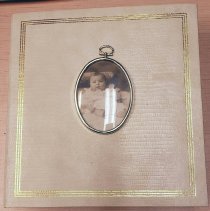 Photo album with image of baby in oval frame on cover
