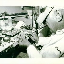 Black & white photo of man working with small tools