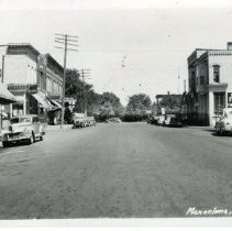 Black & white image of streetscene taken from center of road
