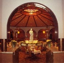 Color postcard w photo of restaurant interior w tables and statue