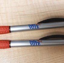 Two plastic ballpoint clicky pens in silver, red, black and blue