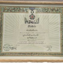 Framed certificate in Arabic with foliage border