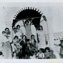 Black & white photo of family under an arched structure