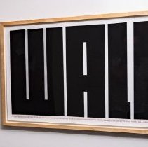 Framed poster of large, block text reading "WALL"