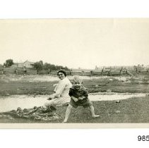 [Unidentified woman, boy, and farm buildings]