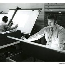 [Two men working at drafting tables]